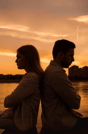 Couple en conflit, assis dos à dos sur un canapé, illustrant une rupture de communication